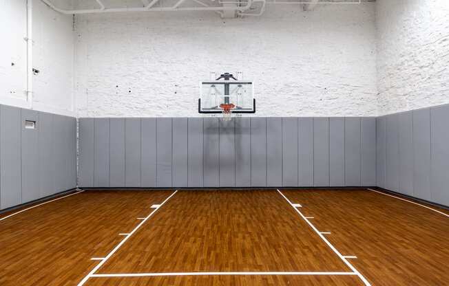 an empty basketball court in a gym with a basketball hoop