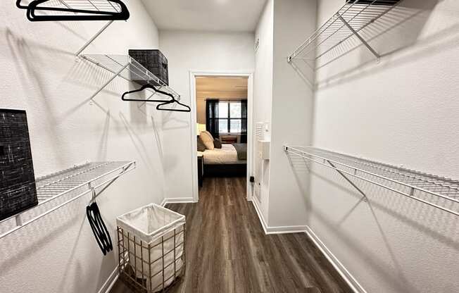 a walk in closet with shelves and a basket on the floor