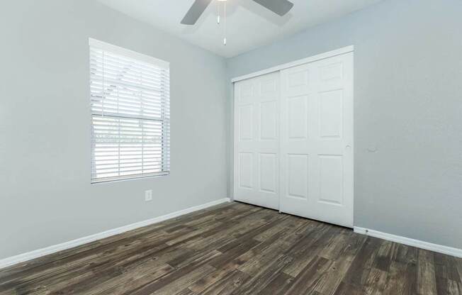 A room with a white door and a window with blinds.
