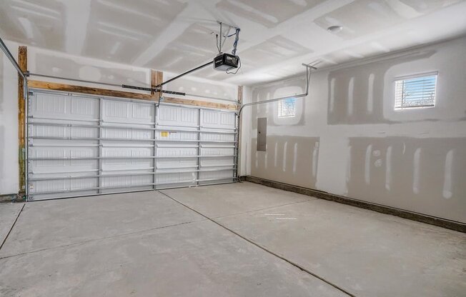 a large garage with white walls and a ceiling with a track light
