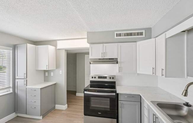 A kitchen with a black stove top oven and white cabinets.