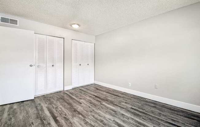 A room with wood flooring and white walls.