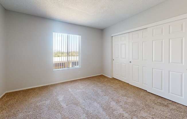 an empty room with carpet and a window