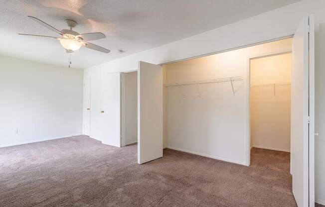 A room with a ceiling fan and carpeted floor at Spring Creek Townhomes Apartments, Springfield