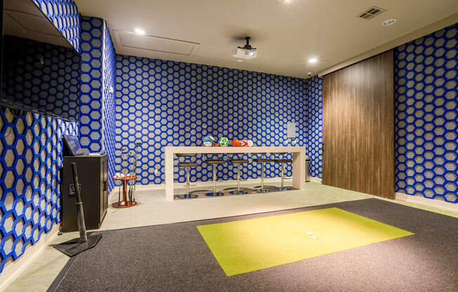 A room with a blue patterned wallpaper and a yellow rug.