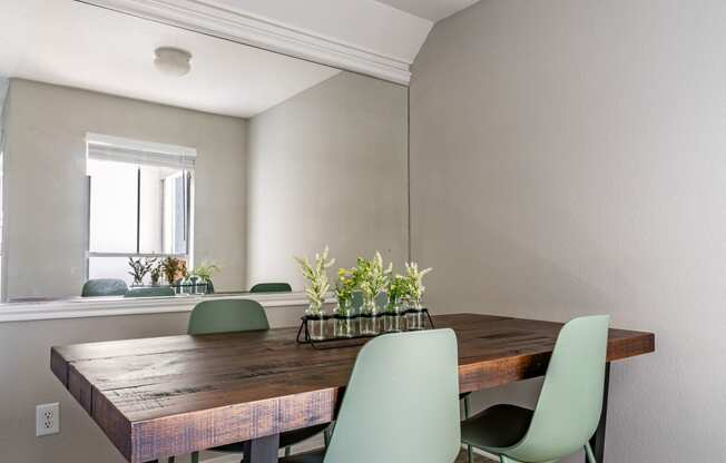 a dining room with a wooden table and green chairs