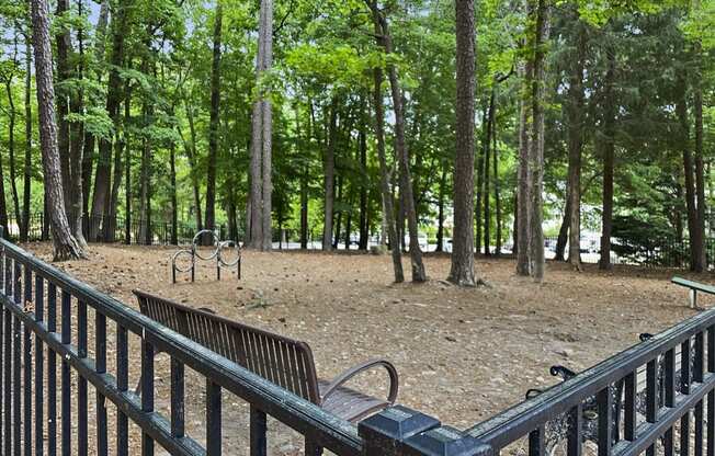 a park with benches and trees and a fence