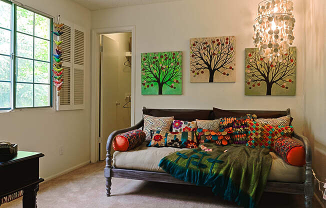 a bedroom with a bed and paintings on the wall