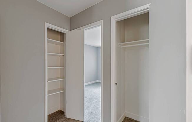 A room with two open doors and a carpeted floor.