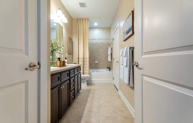 A bathroom with a white door and a beige floor.