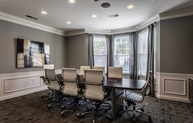 a conference room with a table and chairs and windows