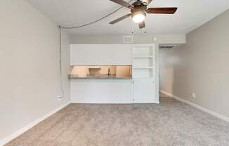 A room with a ceiling fan and a built-in bench.