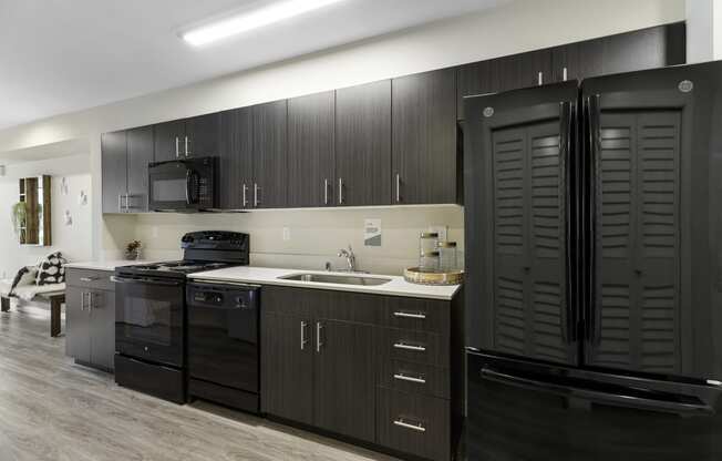 a kitchen with black cabinets and a black refrigerator at Arabella Apartment Homes, Shoreline, 98155