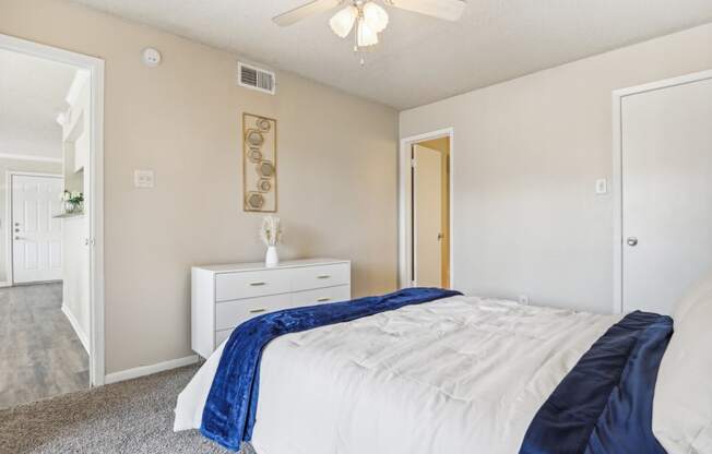 a bedroom with a bed and a ceiling fan