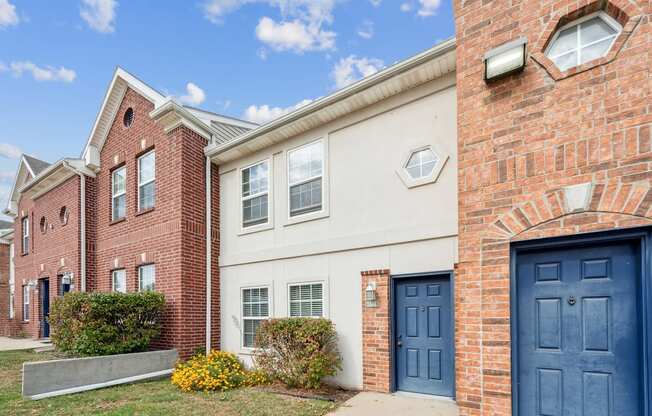 A red brick building with a white door and windows.