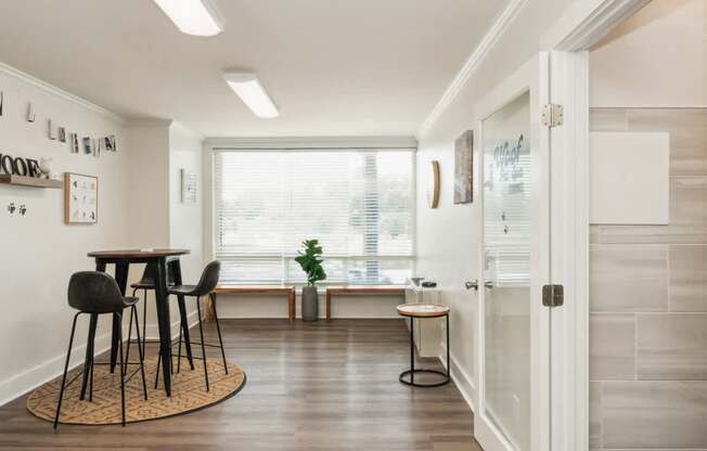 a dining room with a table and chairs and a window at The Lafayette Apartments, Colonial Place, Norfolk