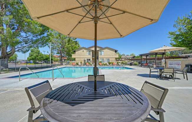 our apartments have a swimming pool and a patio with a table and chairs