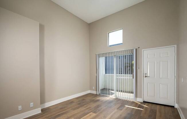 A room with a white door and a window with blinds.