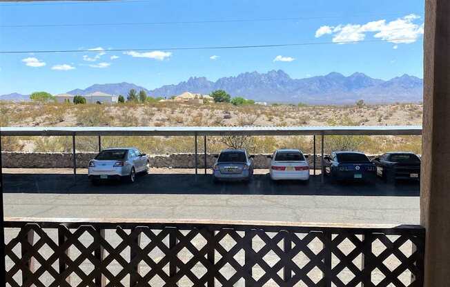 A parking lot with cars and a mountain range in the background.