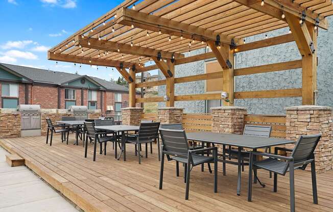 A wooden deck with a table and chairs under a pergola at Mountain Vista Apartments, Lakewood, CO, 80228