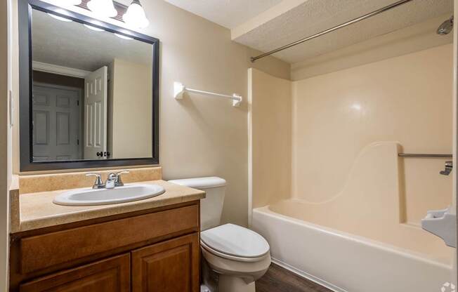 A bathroom with a toilet, sink, and bathtub.