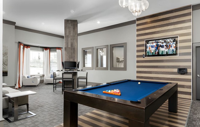 A room with a pool table and a television.