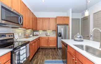 a kitchen with wooden cabinets and stainless steel appliances
