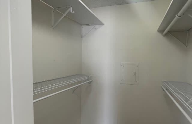 an empty closet with shelves and a shelf on the wall