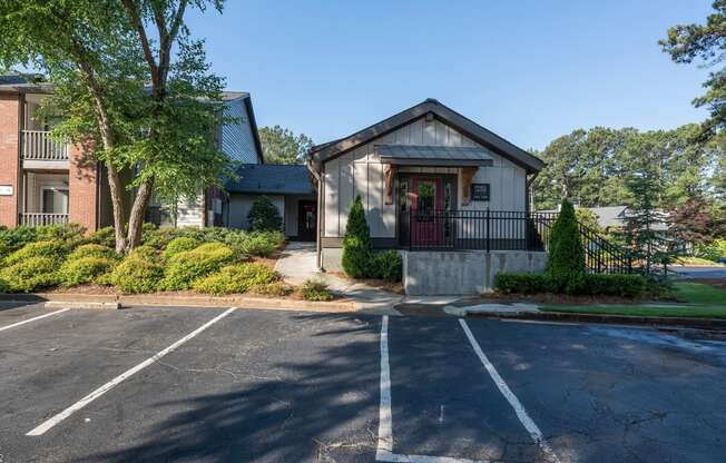 an empty parking lot in front of a house with a porch