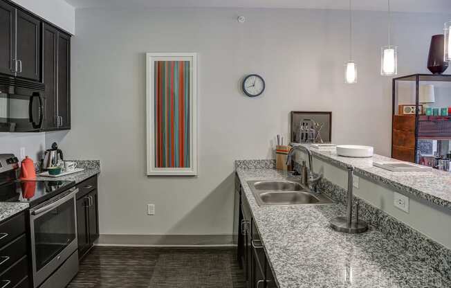 Kitchen with granite counter tops and a sink at Heritage at Oakley Square, Ohio, 45209