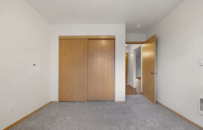 a bedroom with white walls and a carpeted floor