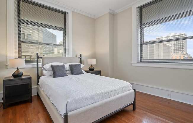 A bedroom with a large bed and a window overlooking a cityscape.