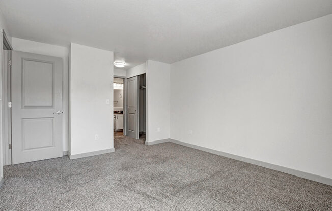 a bedroom with white walls and carpet