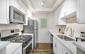 a kitchen with white cabinets and stainless steel appliances