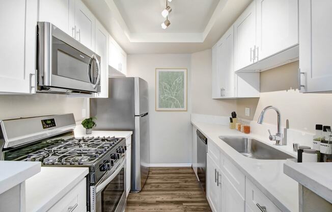 a kitchen with white cabinets and stainless steel appliances