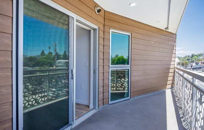 a balcony with glass doors and a view of the city