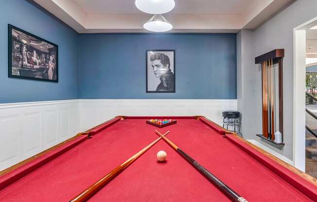 a red pool table in a blue room