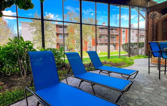 Two blue lounge chairs are placed on a patio.