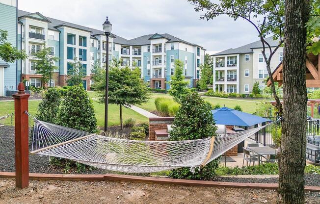 a hammock in a park in front of an apartment building