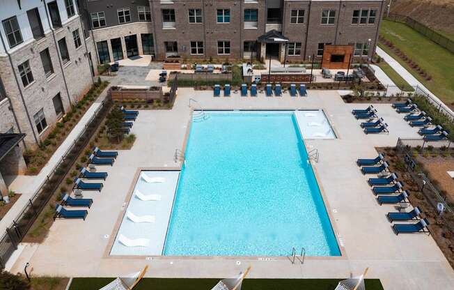 an aerial view of a swimming pool in front of an apartment building