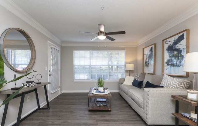 a living room with a ceiling fan and a large window