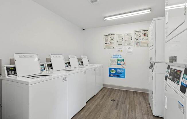 A laundry center with a row of washing machines and dryers at Gwinnett Square Apartments in Duluth, GA