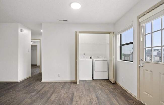 A white room with a washer and dryer in it.