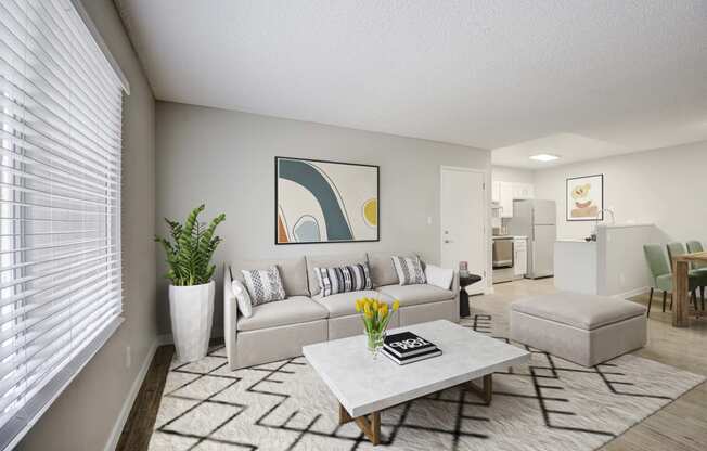 Dog-Friendly Apartments in Glendale, AZ - Spectra West - Living Room with a Sofa, an Ottoman, a Coffee Table, a Large Window, Wood-Style Flooring, and Stylish Decor