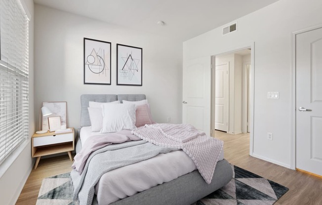 a bedroom with white walls and a gray bed