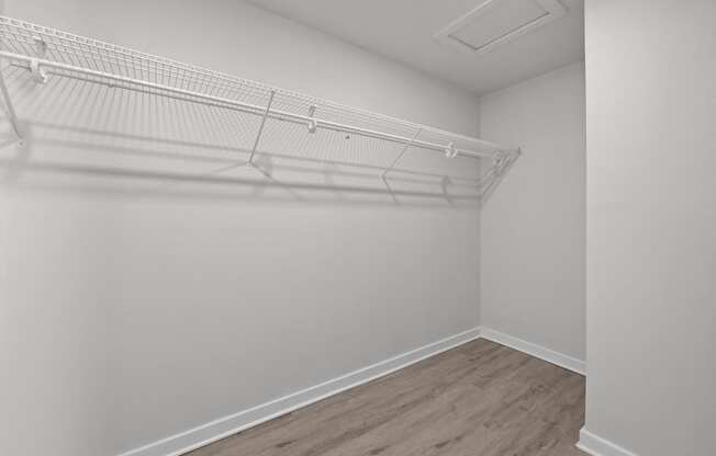 an empty bedroom with white walls and a white closet with a white rack on top at Sunset Heights, Texas, 78209