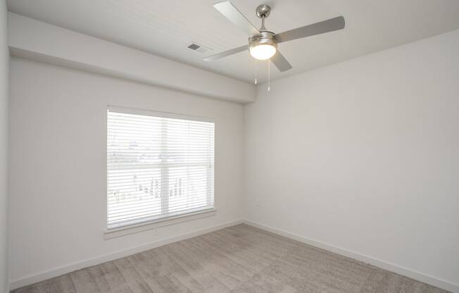 a bedroom with a ceiling fan and a window