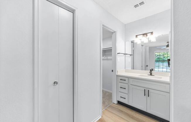 A white bathroom with a sink, mirror, and medicine cabinet.