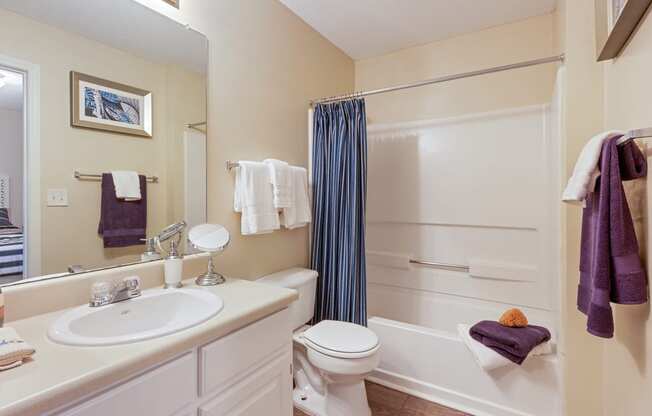 bathroom with hardwood-style flooring and white cabinetry