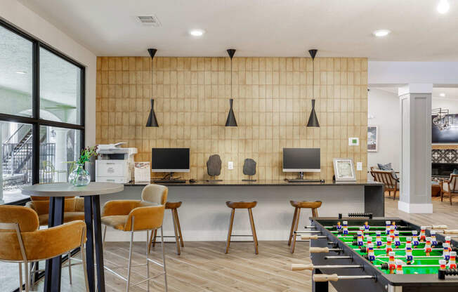 a games room with a foosball table and computer monitors